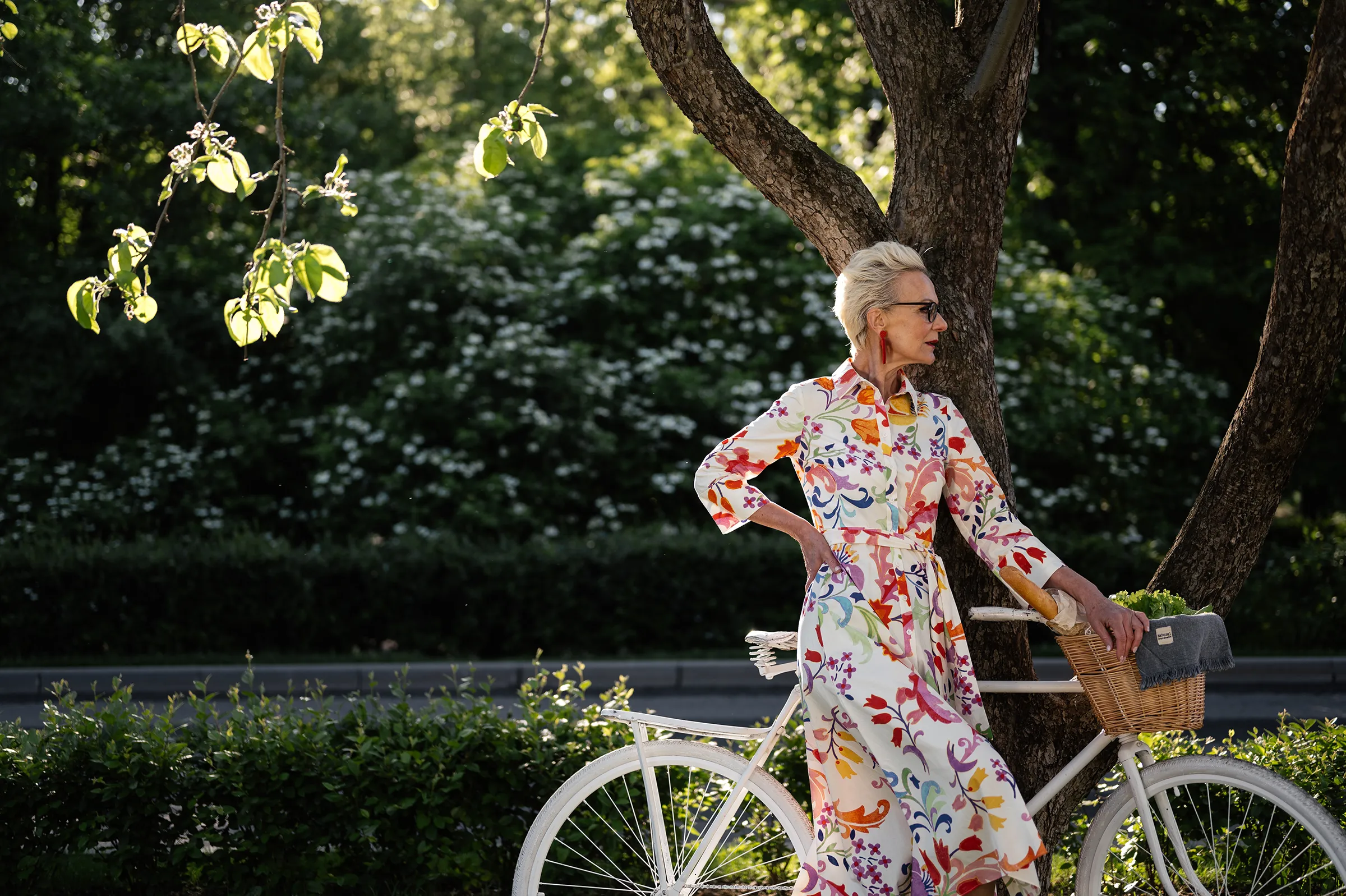 senior woman posing by bike outside