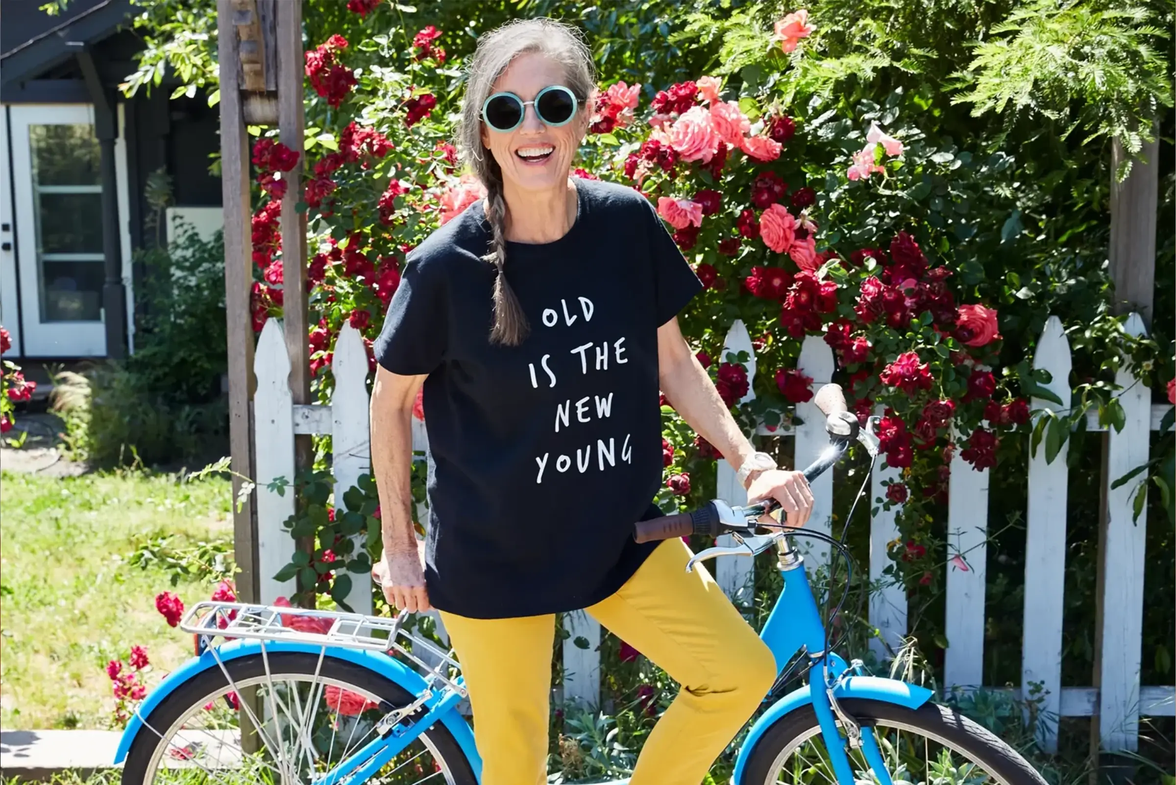 independent living resident standing by bike with old is the new young shirt