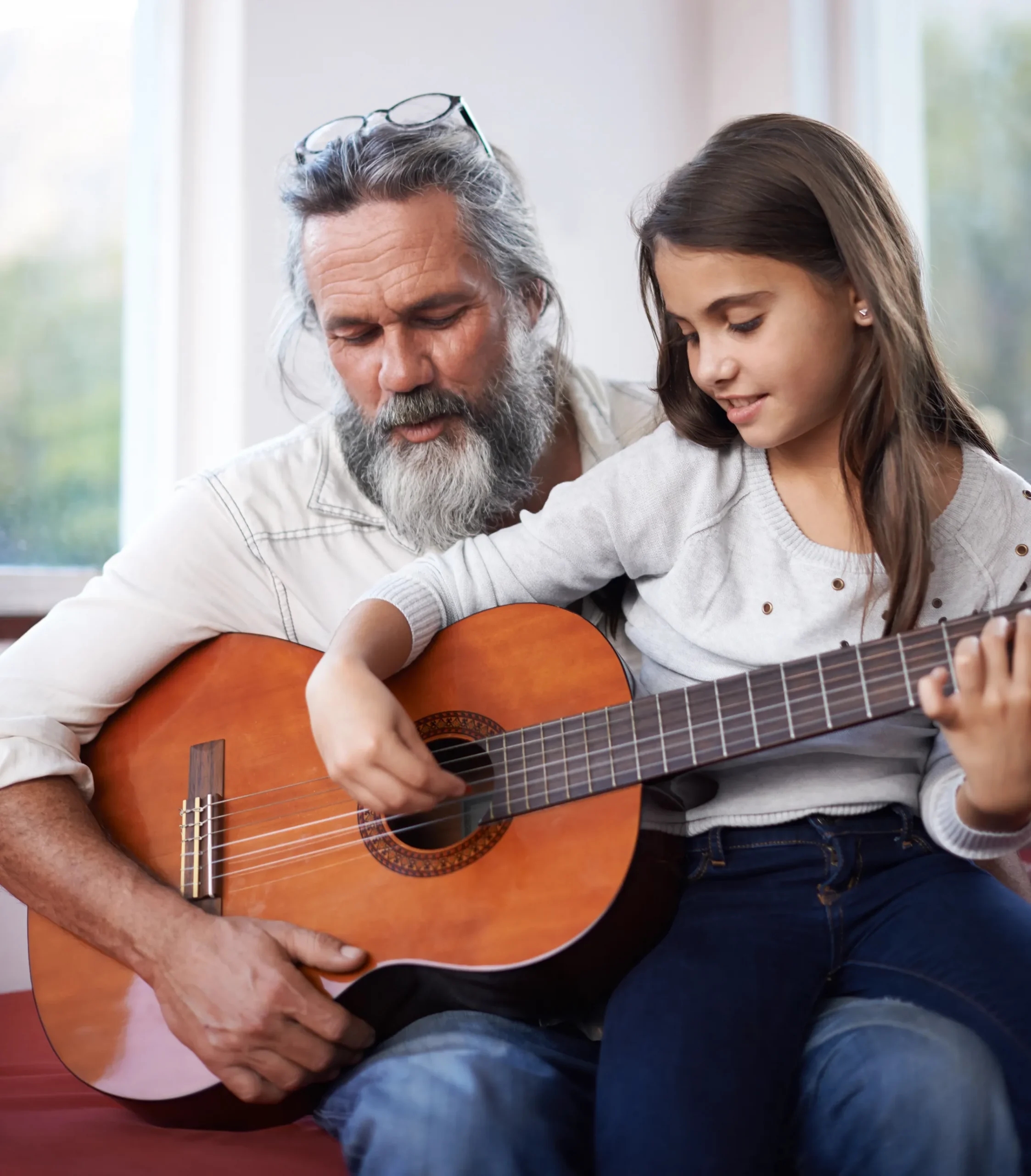 man with young girl playing guitar