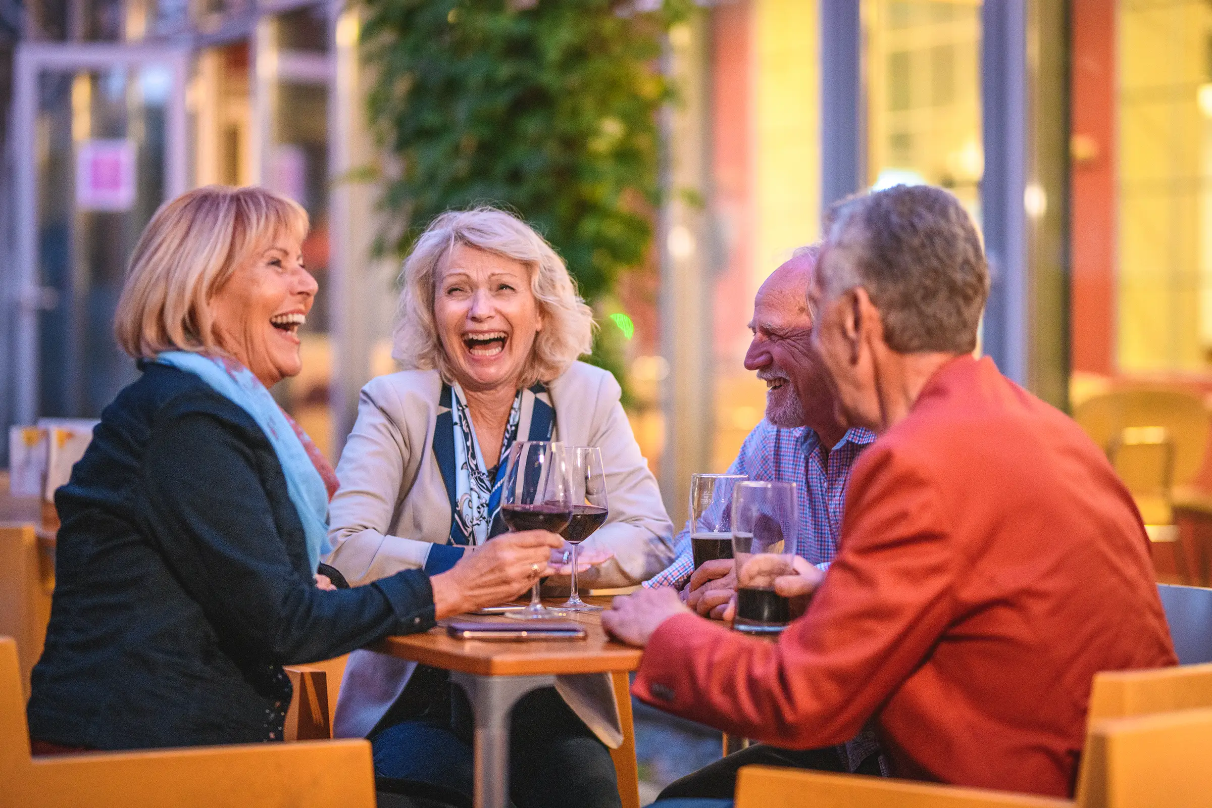 two senior couples enjoying time together at a table outside