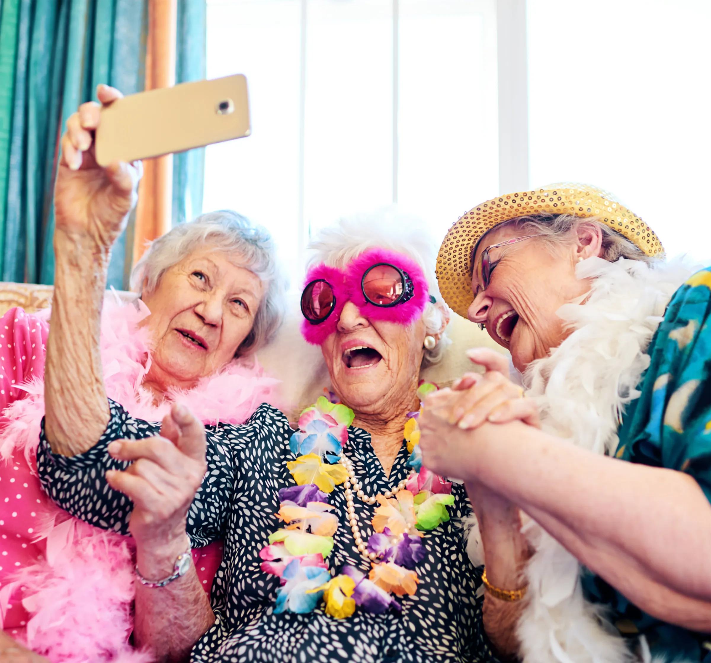 Three female residents wearing costumes laughing as they take a selfie together.